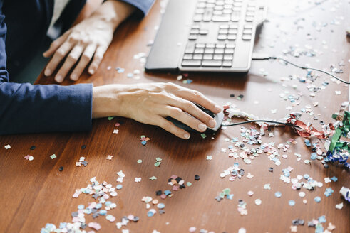 Hand of a woman working on a desk full of confetti - KNSF02750