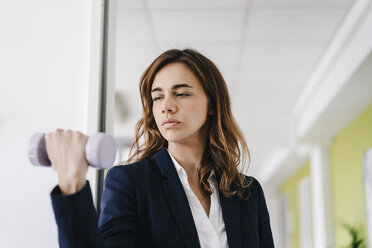 Businesswoman training with a dumbbell - KNSF02756