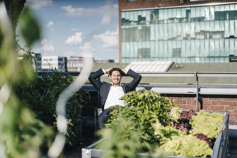 Businessman relaxing in his urban rooftop garden stock photo