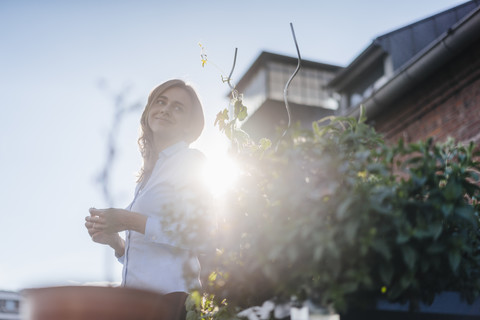 Businesswoman standing on her urban rooftop garden stock photo