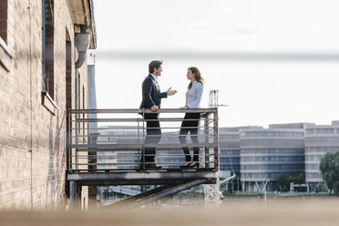 Business people standing on balcony, discussing - KNSF02809