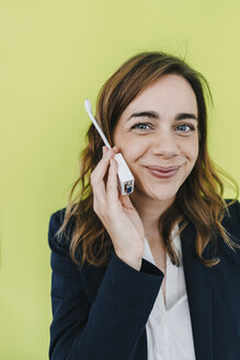 Businesswoman using computer plug as telephone - KNSF02842