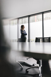 Successful businesswoman standing in board room - KNSF02845