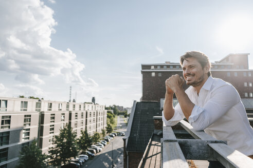 Geschäftsmann auf Balkon stehend, lächelnd - KNSF02858