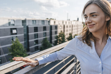 Geschäftsfrau steht auf der Terrasse eines Industriegebäudes - KNSF02867