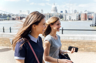 UK, London, zwei Frauen gehen am Ufer der Themse entlang - MGOF03601