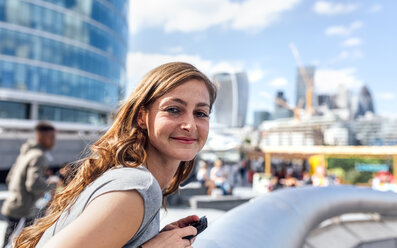 UK, London, portrait of smiling woman in the city - MGOF03608