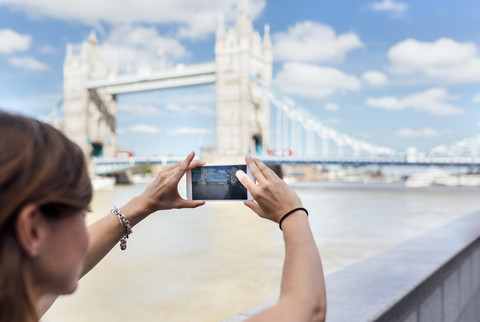 UK, London, Frau fotografiert die Tower Bridge, lizenzfreies Stockfoto