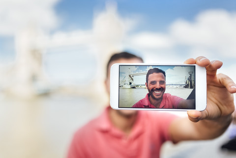 UK, London, Tourist macht ein Selfie mit der Tower Bridge, lizenzfreies Stockfoto