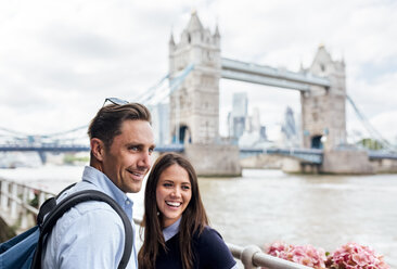 Großbritannien, London, lächelndes Paar mit der Tower Bridge im Hintergrund - MGOF03622
