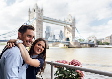 Großbritannien, London, lächelndes Paar mit der Tower Bridge im Hintergrund - MGOF03624