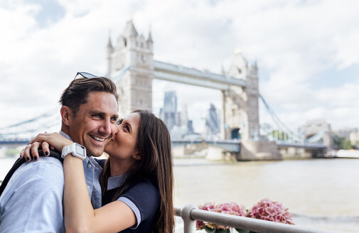 Großbritannien, London, glückliches Paar küsst sich mit der Tower Bridge im Hintergrund - MGOF03625