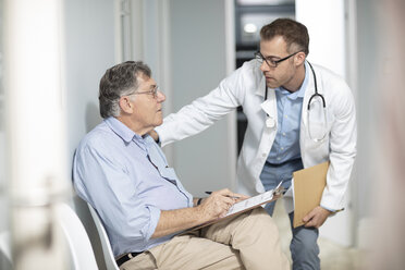 Arzt im Gespräch mit einem Patienten mit Akte in einer Arztpraxis - ZEF14541