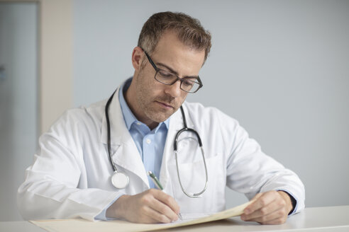 Doctor doing paperwork at desk - ZEF14543