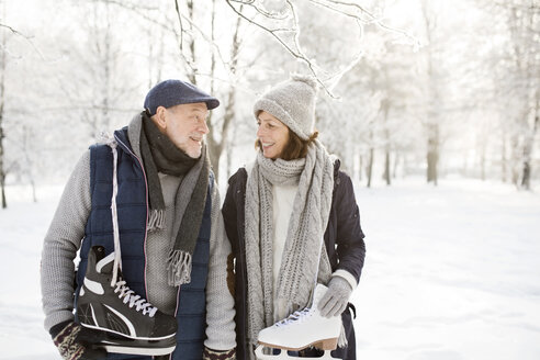 Älteres Paar mit Schlittschuhen in Winterlandschaft - HAPF02126