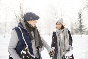 Älteres Paar mit Schlittschuhen in einer Winterlandschaft - HAPF02127