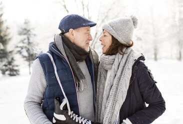 Älteres Paar mit Schlittschuhen in Winterlandschaft - HAPF02129