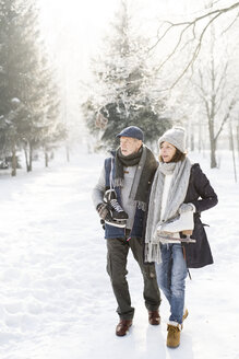 Älteres Paar mit Schlittschuhen in einer Winterlandschaft - HAPF02132