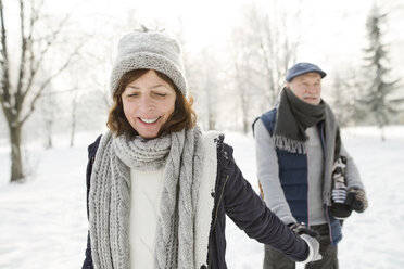 Glückliches älteres Paar mit Schlittschuhen in einer Winterlandschaft - HAPF02134