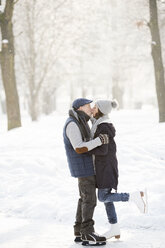 Senior couple hugging and kissing on frozen lake - HAPF02154