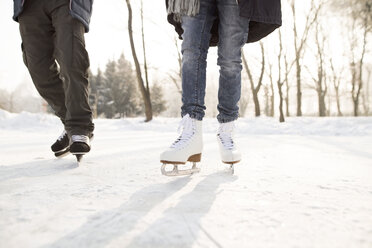 Close-up of two ice skaters on frozen lake - HAPF02156