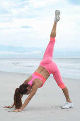 Frau übt Yoga am Strand - ABAF02170