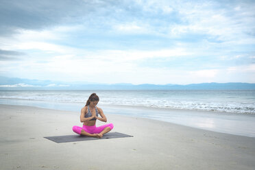 Frau übt Yoga am Strand - ABAF02173