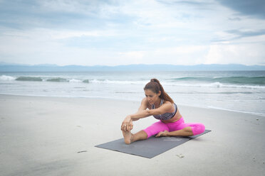 Frau übt Yoga am Strand - ABAF02174