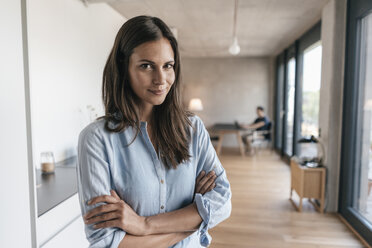 Portrait of smiling woman at home with man in background - JOSF01550