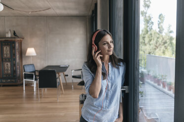 Relaxed woman listening to music at home - JOSF01558