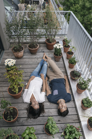 Entspanntes Paar auf dem Balkon liegend, lizenzfreies Stockfoto