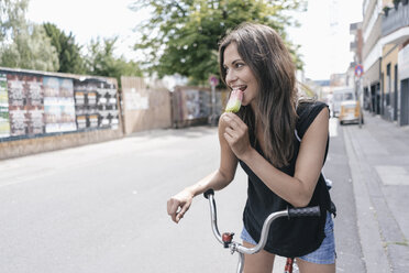 Frau mit Fahrrad isst Eislutscher - JOSF01605