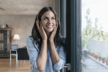 Smiling woman listening to music at home - JOSF01610