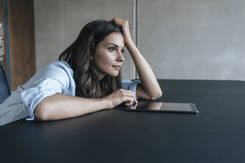 Woman with tablet leaning on table - JOSF01612