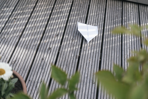 Paper plane on wooden terrace stock photo