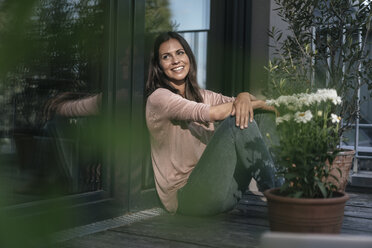 Smiling woman relaxing on balcony - JOSF01623