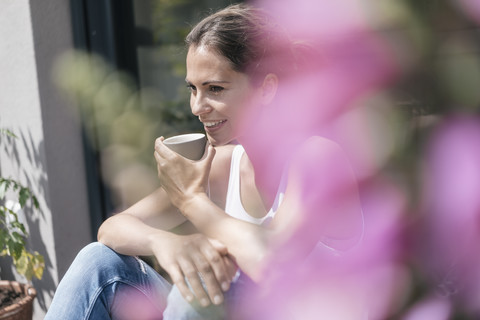 Smiling woman relaxing on balcony stock photo