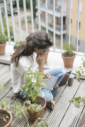 Woman with laptop sitting on balcony - JOSF01638