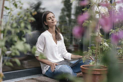 Woman with laptop sitting on balcony - JOSF01643