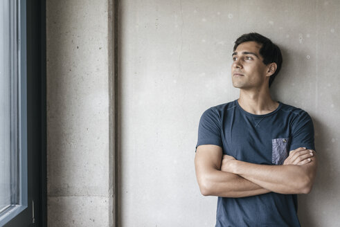 Young man looking out of window - JOSF01647