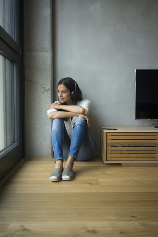 Entspannte Frau beim Musikhören zu Hause, lizenzfreies Stockfoto