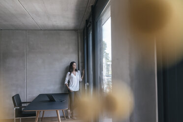 Frau schaut aus dem Fenster - JOSF01665