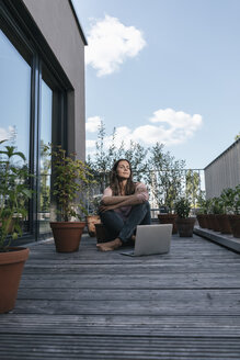 Frau mit Laptop auf dem Balkon sitzend - JOSF01689