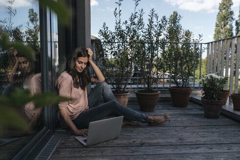 Woman with laptop sitting on balcony - JOSF01691