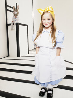 Porträt eines lächelnden kleinen Mädchens, das sich als Alice im Wunderland verkleidet hat - FSF00956