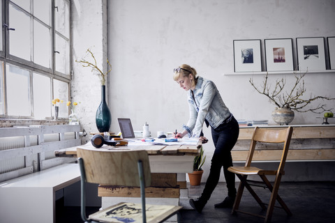 Woman working at desk in a loft stock photo