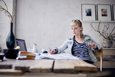 Frau arbeitet am Schreibtisch in einem Loft - RBF05973