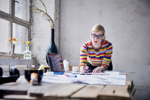 Porträt einer Frau bei der Arbeit am Schreibtisch in einem Loft - RBF05978