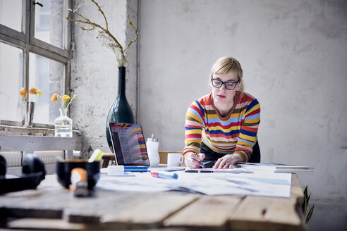 Portrait of woman working at desk in a loft - RBF05978