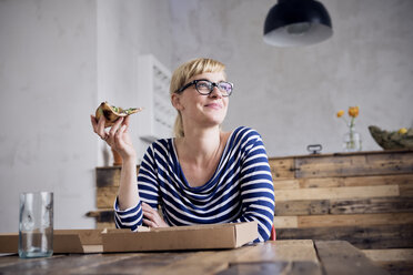 Portrait of smiling woman eating pizza - RBF05998